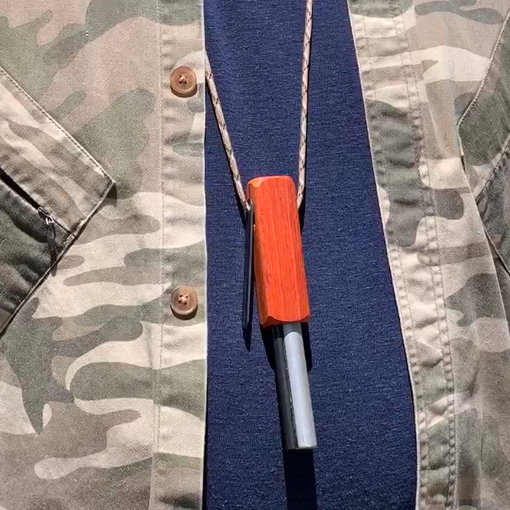 Fire-Fast Kamper Lanyard in worn 'lanyard style' – vibrant Padauk African hardwood handle with thick ferro rod, camo 550 paracord fully unwrapped and ready for neck carry or tethering