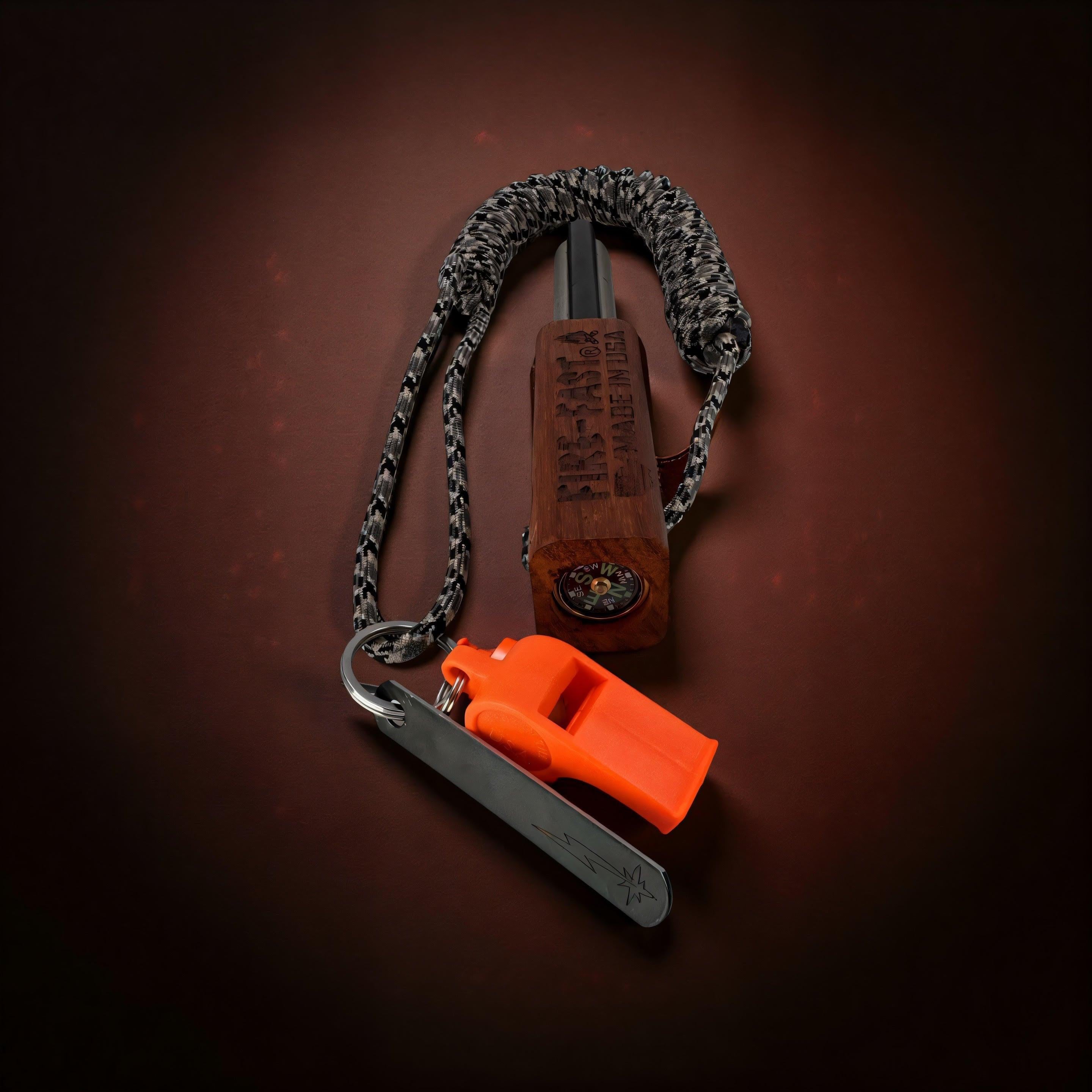 Fire-Fast Trekker Tracker ferro rod with 13' 1000lb 15-strand nylon paracord, compass, whistle, and striker on rocks – ultimate survival multi-tool.