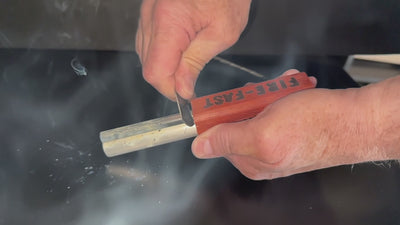 Hands demonstrating USA-made Fire-Fast Trekker waterproof fire starter scraping striker against ferrocerium rod to produce extreme heat and flame-thrower level sparks for reliable ignition in survival scenarios.